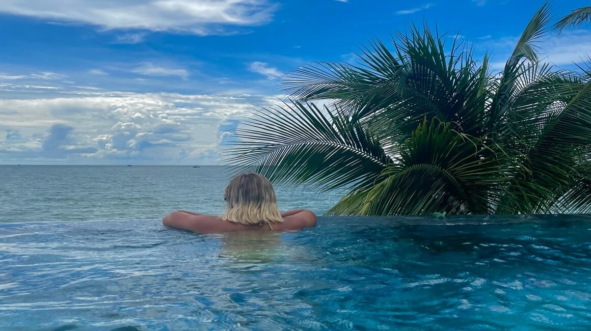 Woman overlooking an infinity pool out to the ocean in Phu Quoc