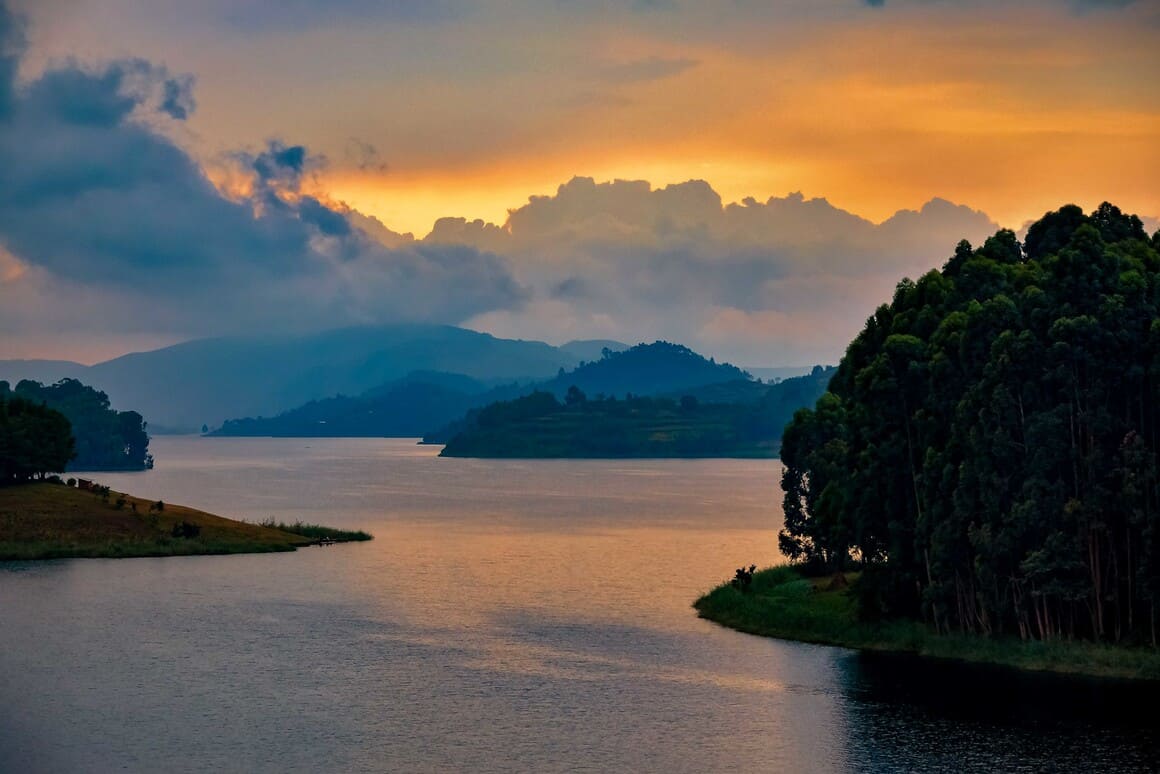 green hills and orange sunset over lake bunyonyi in uganda