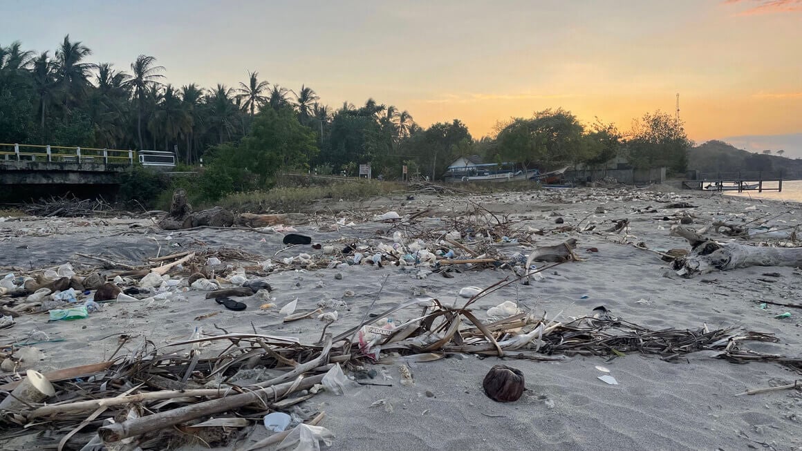 trash covering a beach in lombok, indonesia