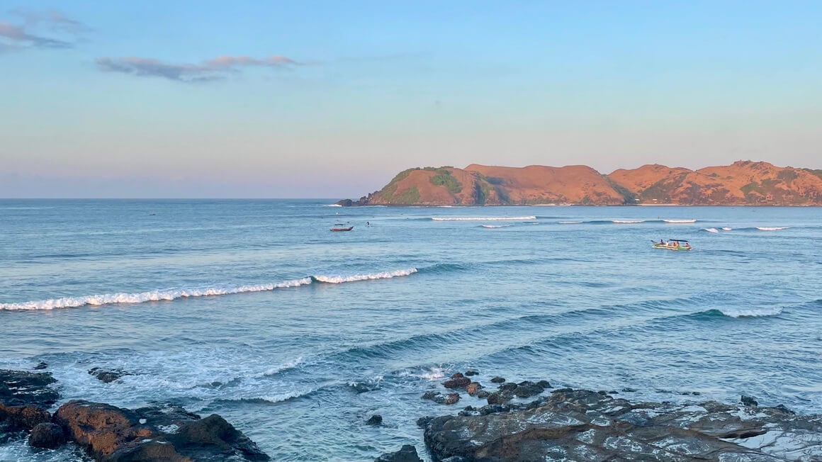 tanjung aan beach at sunrise, view across the surf and over the the hills, lombok, indonesia