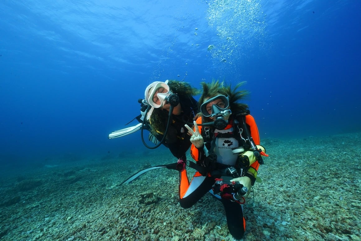 Two girls scuba diving in the crystal clear waters of Bali.