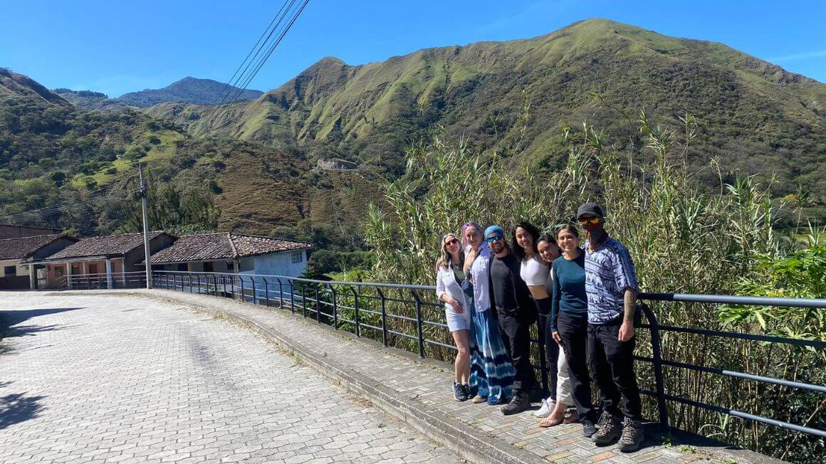 A group of people standing in the mountains on a bridge in Ecuador