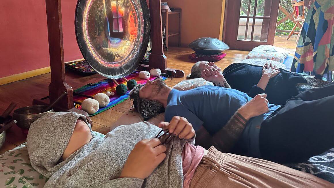 three people laid down on the floor of a spiritual retreat in Ecuador whilst meditating and healing