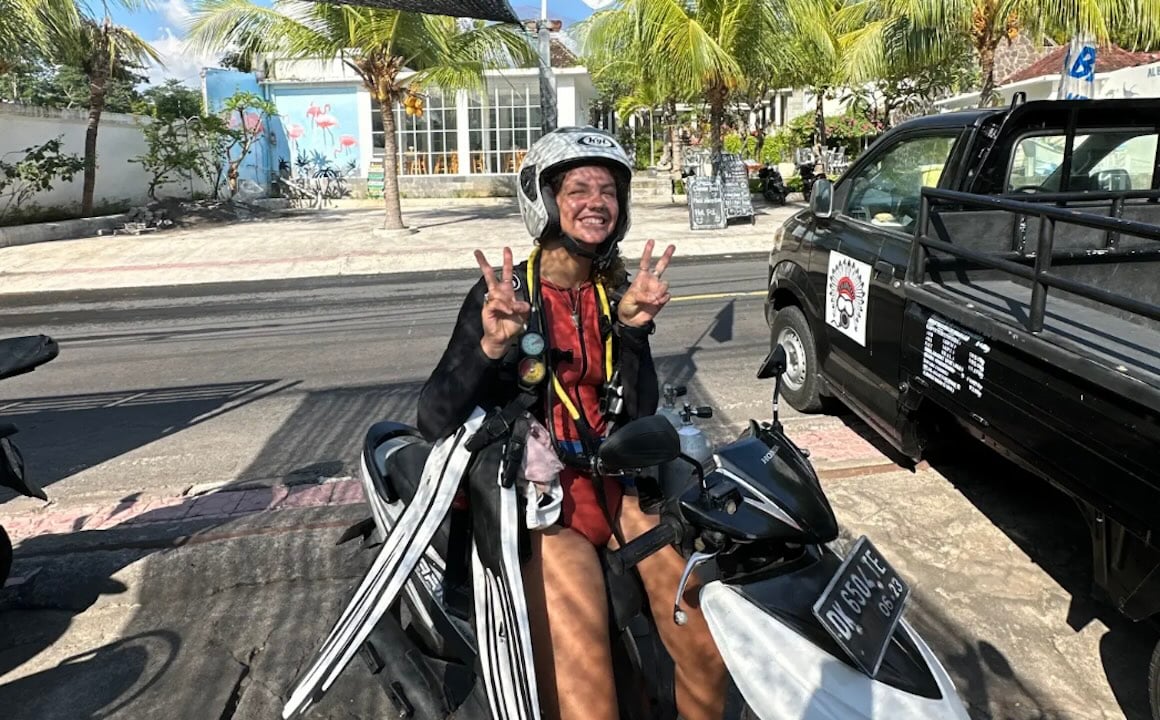 Audy on a scooter in Amed, Bali, getting ready to go diving.