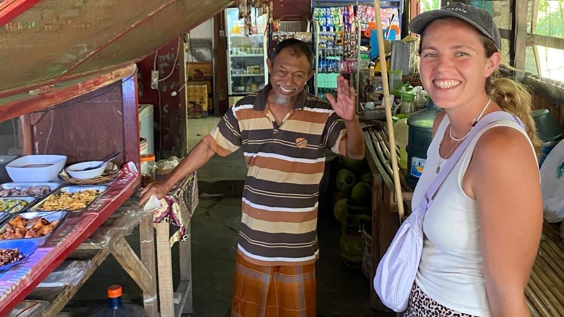 Dani and a local Indonesian man smiling at his warung