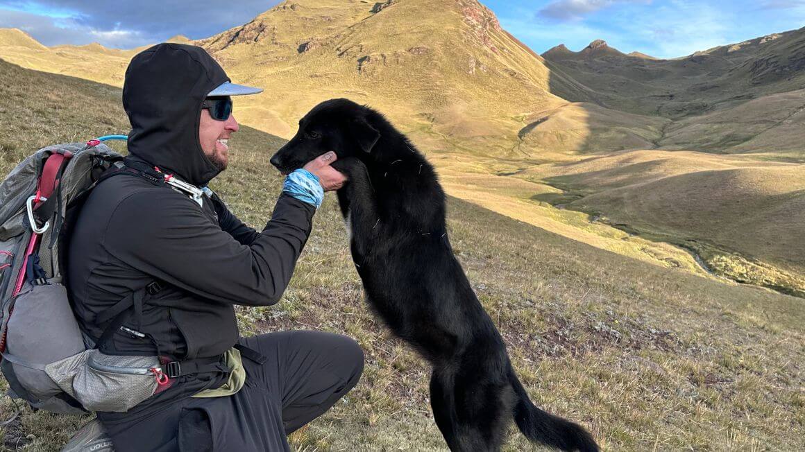 Will playing with a dog in the mountains of Peru whilst hiking