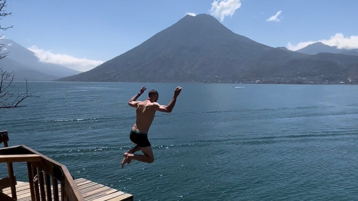 Joe jumping into Lake Atitlan from 10 metres in his underwear with a volcano in the background