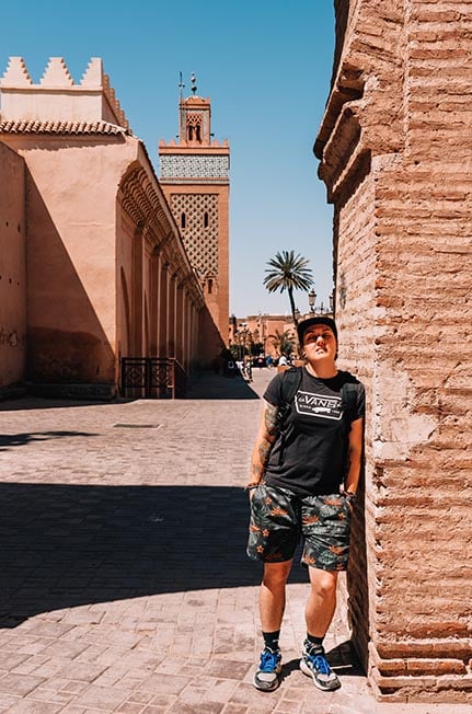 Nic standing next to a wall with a mosque behind them in Marrakesh, Morocco