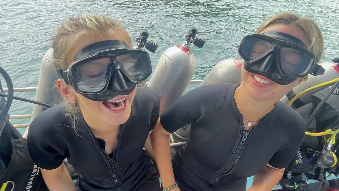 two girls laughing on a dive boat in koh tao, thailand