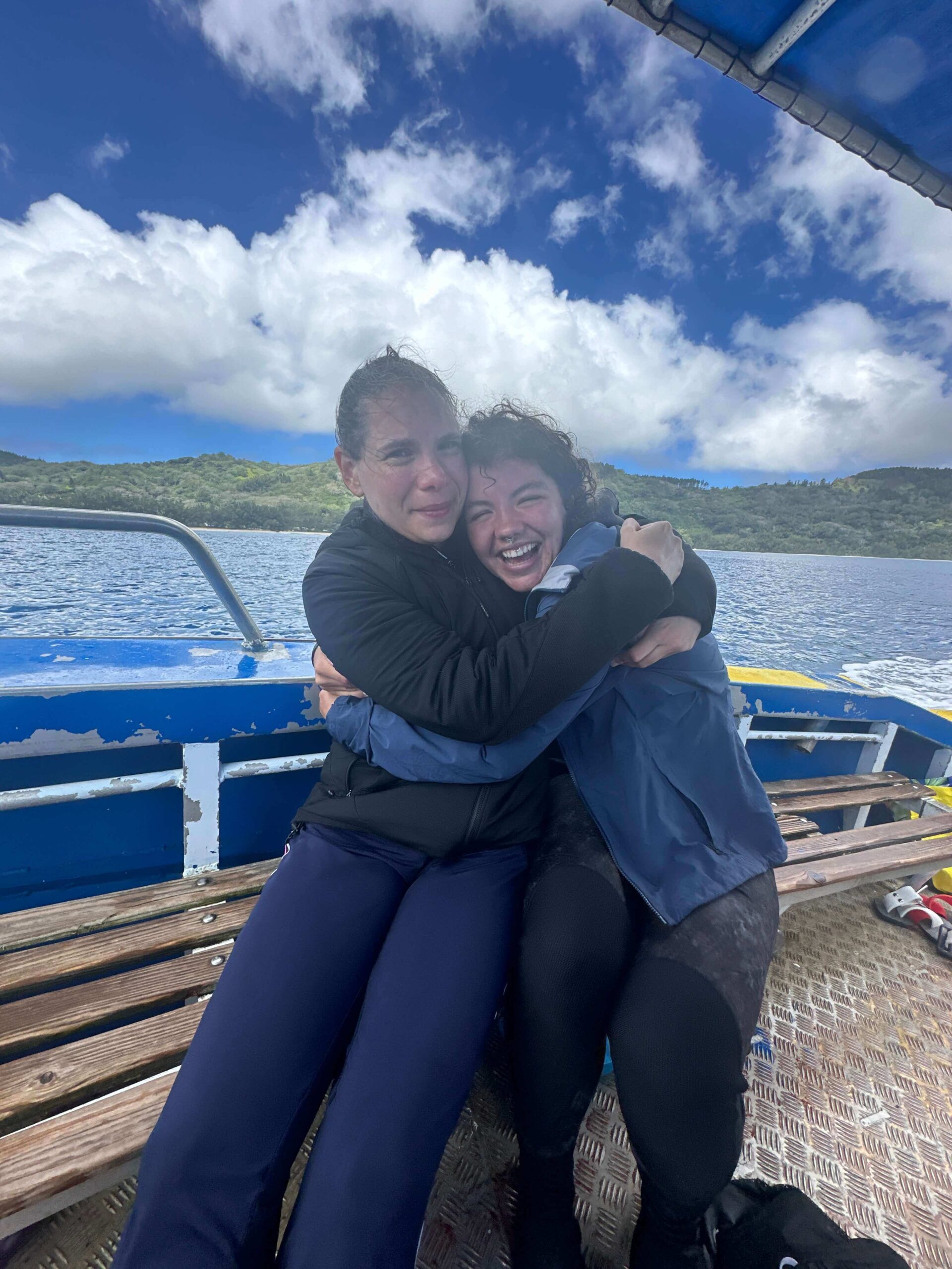 audy and another diver hugging on a boat in french polynesia after swimming with rurutu whales