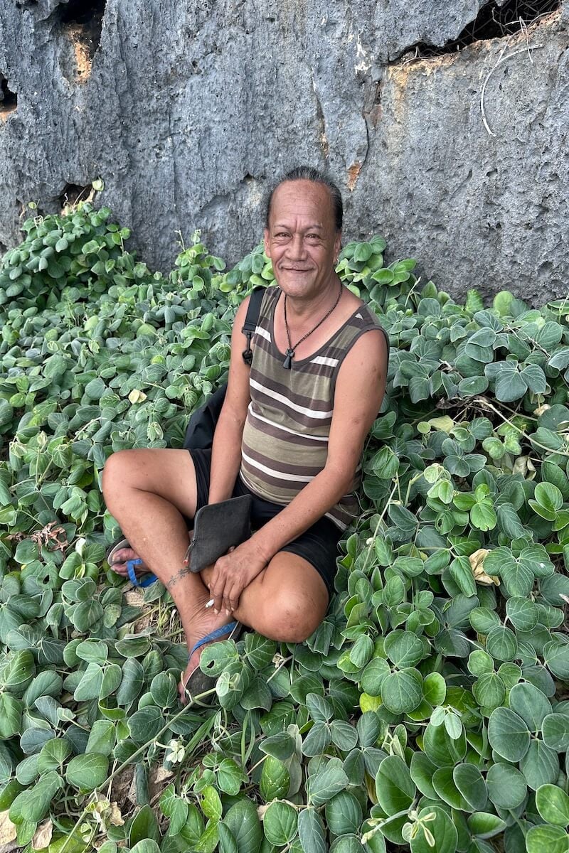 rurutu french polynesia tour guide sitting in a field of green plants