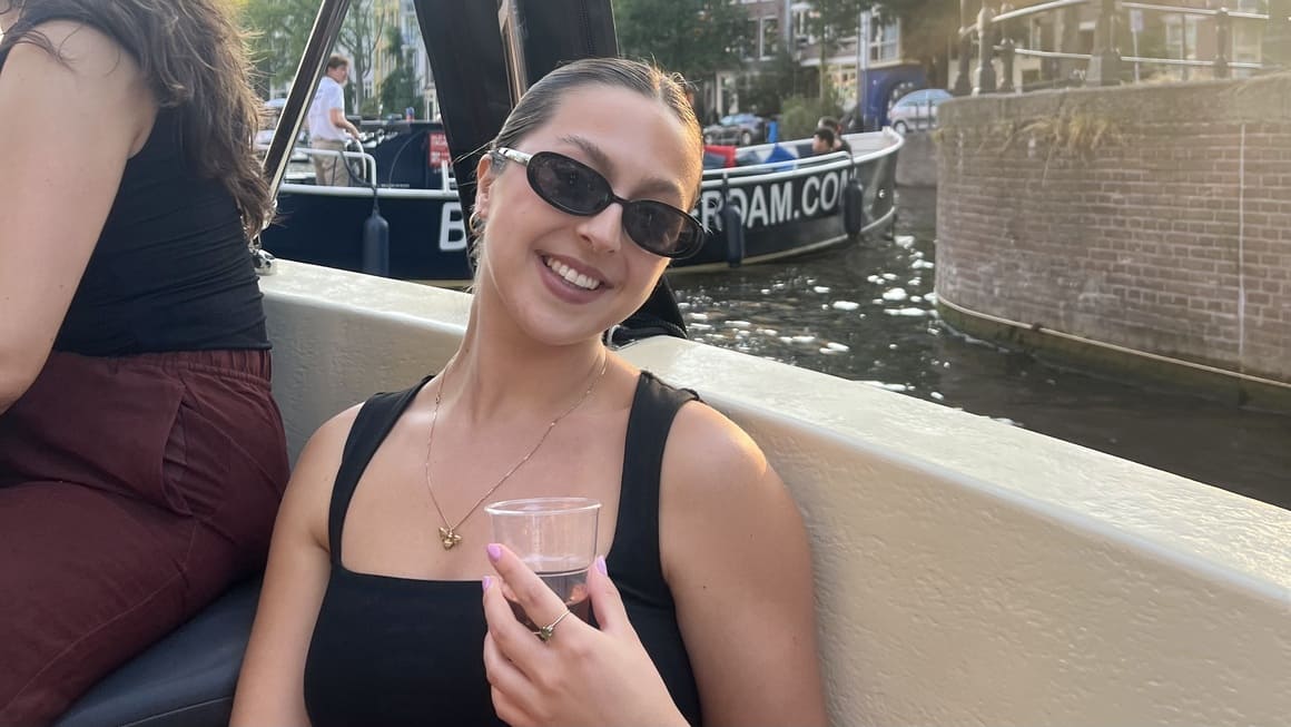 a girl drinking wine on a canal cruise in amsterdam