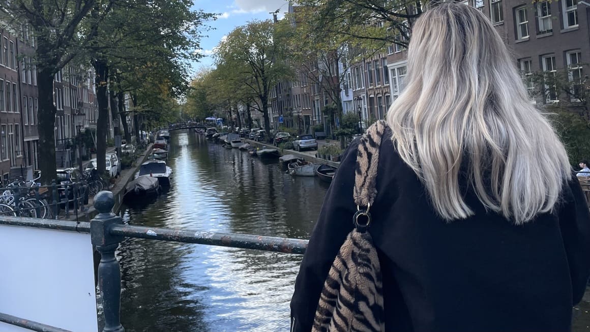 girl looking out to a canal in amsterdam