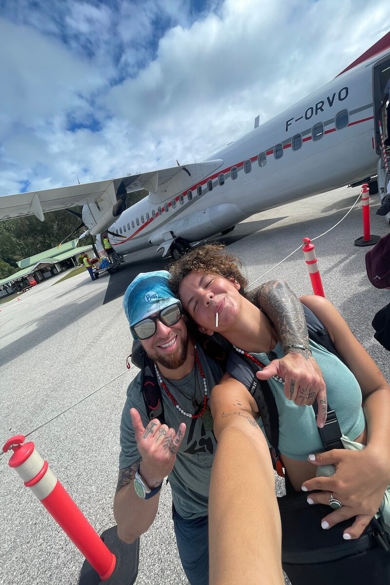 audy and will standing in front of a propellar plane to swim with rurutu whales in french polynesia