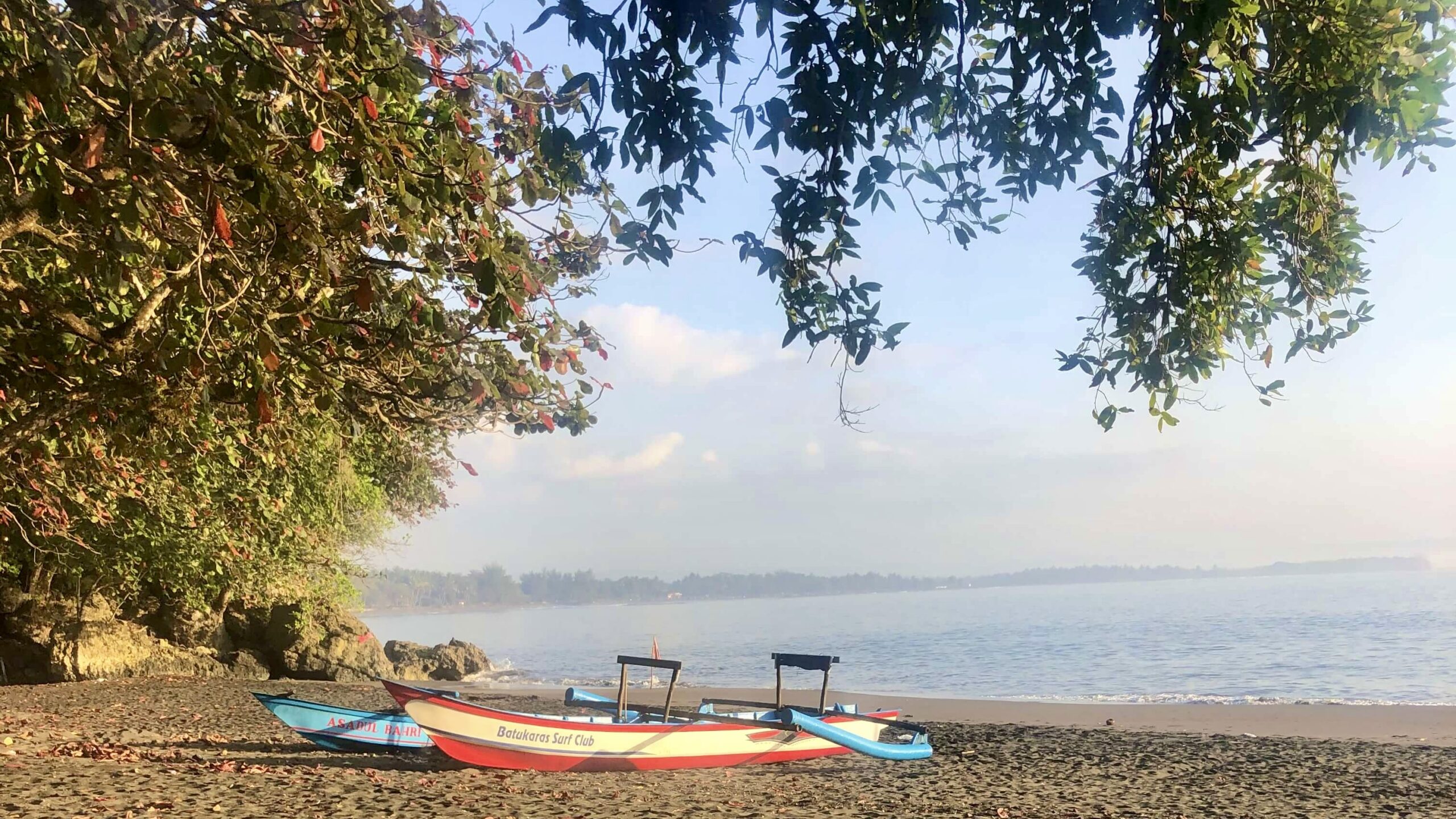 Two traditional Indonesian fishing boats sitting on the beach at sunrise in Batukaras, West Java, Indonesia