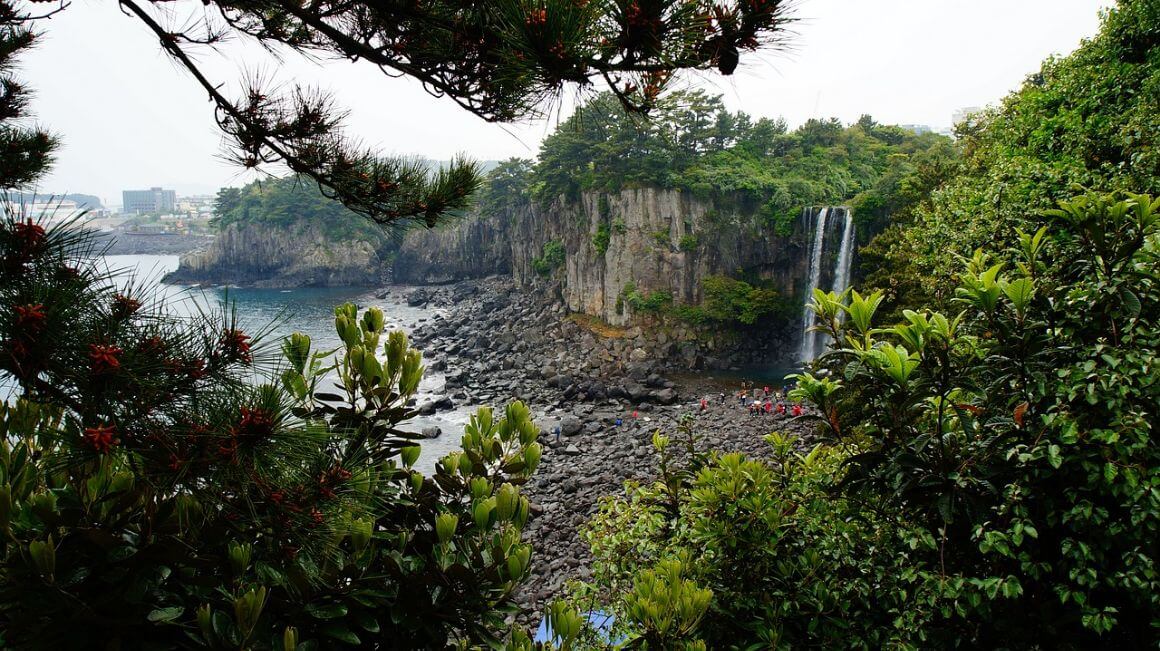 Incredible greenery, cliiffs and rocky ocean side at jeju Jeongbang Waterfall 