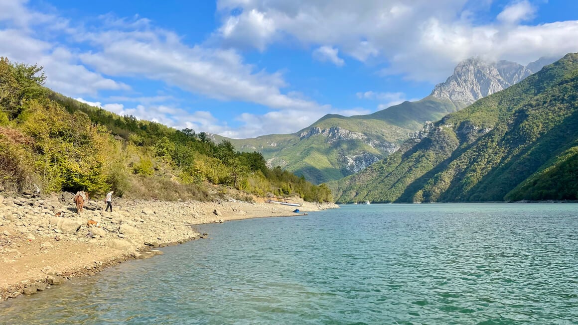 turquoise blue water and green mountains in the background