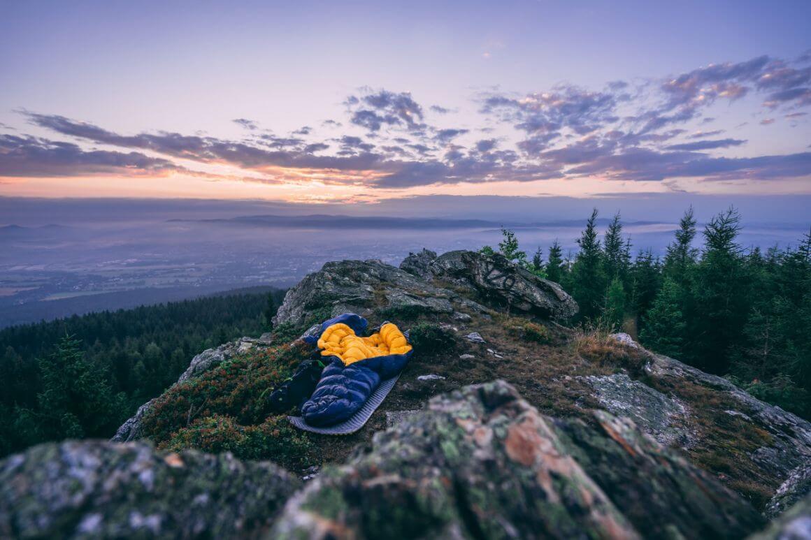 sleeping bag laying on mountain during sunrise