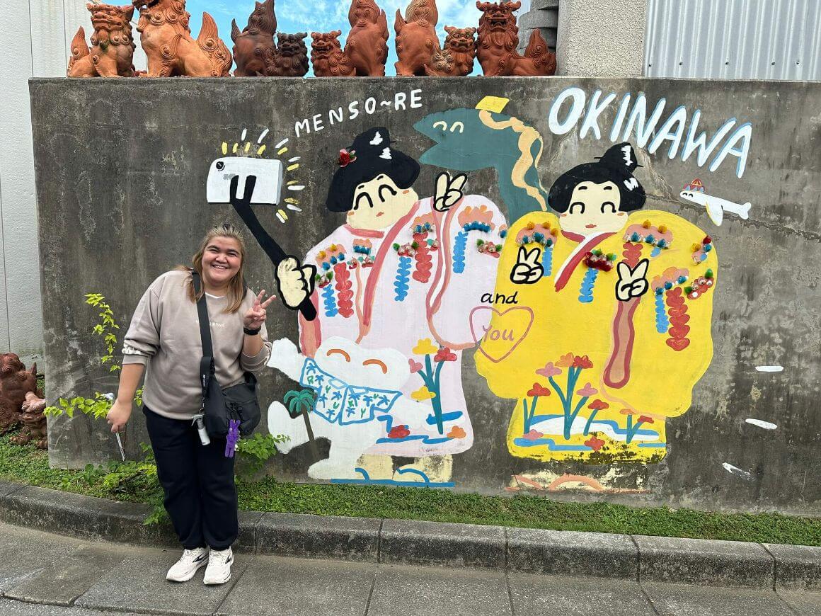 female traveller taking photo at graffiti wall