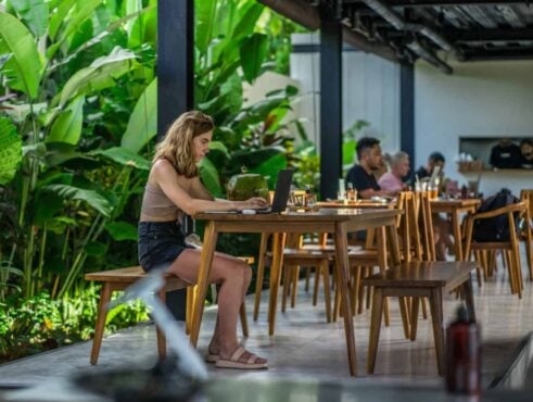 A woman is working on a laptop in the coworking hostel of Tribal in Bali, Indonesia