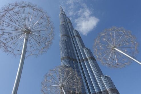 Looking up at the Burj Khalifa from the ground with metal dandelion sculptures in the foreground. United Arab Emirates.