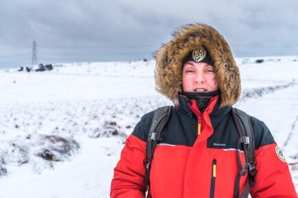 Nic standing on the snowy moors in the North of England in a thick winter jacket/ coat. United Kingdom.