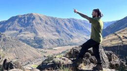 Will doing his best adventure post whilst looking out over the mountains and a village below whilst on the Inca Trail in Peru